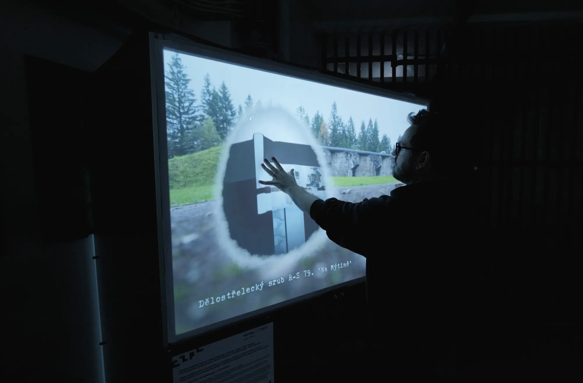 An interactive touch projection at the Hanička fortress that dissolves archival photos into their present-day views, plus an offline audio guide in four languages.