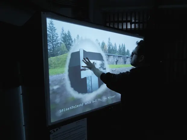 An interactive touch projection at the Hanička fortress that dissolves archival photos into their present-day views, plus an offline audio guide in four languages.